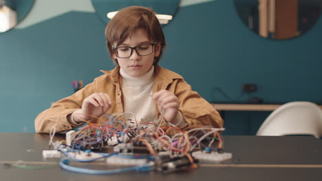 young boy engaged in electronics project