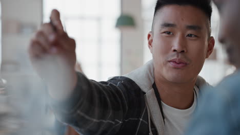 attractive young asian man training colleague pointing at screen sharing ideas enjoying creative teamwork in workplace