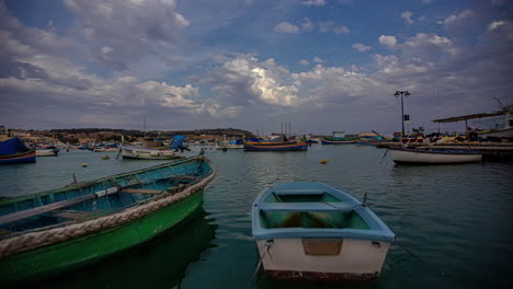 barcos anclados en el puerto de marsaxlokk, malta con un increíble lapso de tiempo del paisaje nuboso