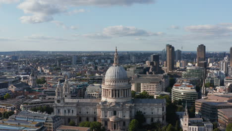 Forwards-fly-shot-of-baroque-Saint-Pauls-Cathedral.-Religious-landmark-on-Ludgate-Hill.-Tall-modern-buildings-in-background.-Aerial-panoramic-view.-London,-UK