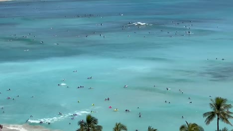 tourists visiting waikiki beach in honolulu, hawaii