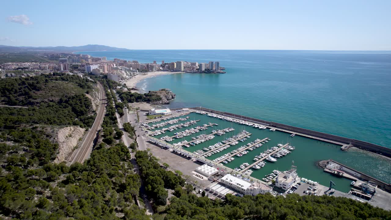 Slow 4K drone fly by aerial footage over the hill upon Oropesa del Mar sport port nautical club in the Mediterranean Sea in Spain