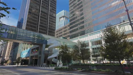 downtown houston streetscene with skyscrapers and bridge between buildings