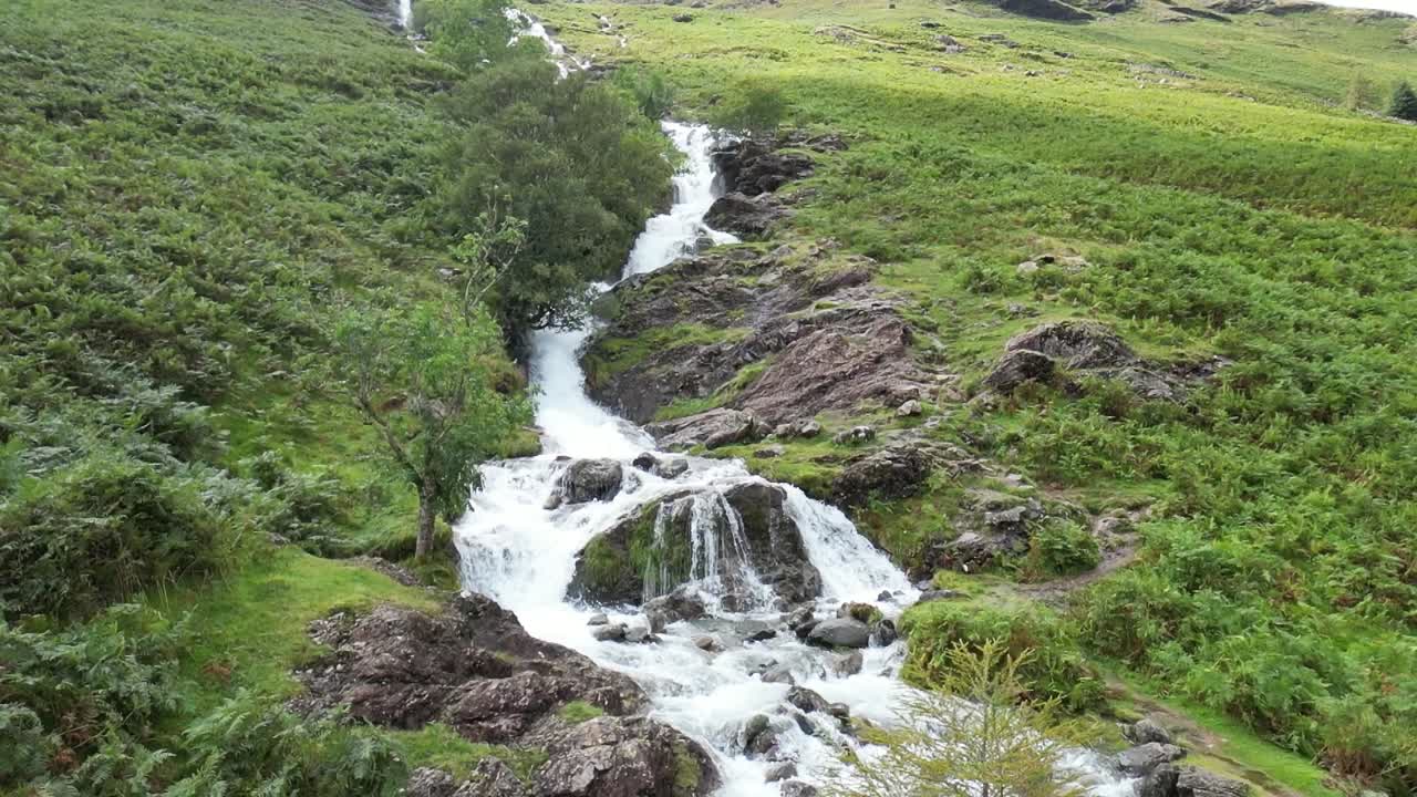 la furiosa cascada que cae en cascada por la montaña es en cámara lenta después de días de fuertes lluvias, dron aéreo parte 3, montaña baja, buttermere, distrito de los lagos, reino unido