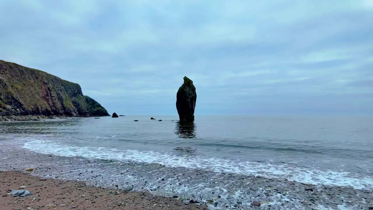 Timelapse Irland, Episke Steder, indkommende tidevand på stenstrand med stille hav i roligt vejr, Ballydwane, Copper Coast, Waterford, Irland