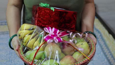 Envoltura-De-Regalo-De-Frutas-Llena-De-Diferentes-Frutas-Y-Paquete-De-Regalo-A-Mano-Desde-Un-ángulo-Plano