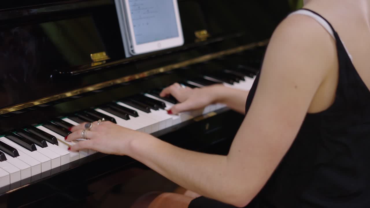 Woman playing the piano with a tablet