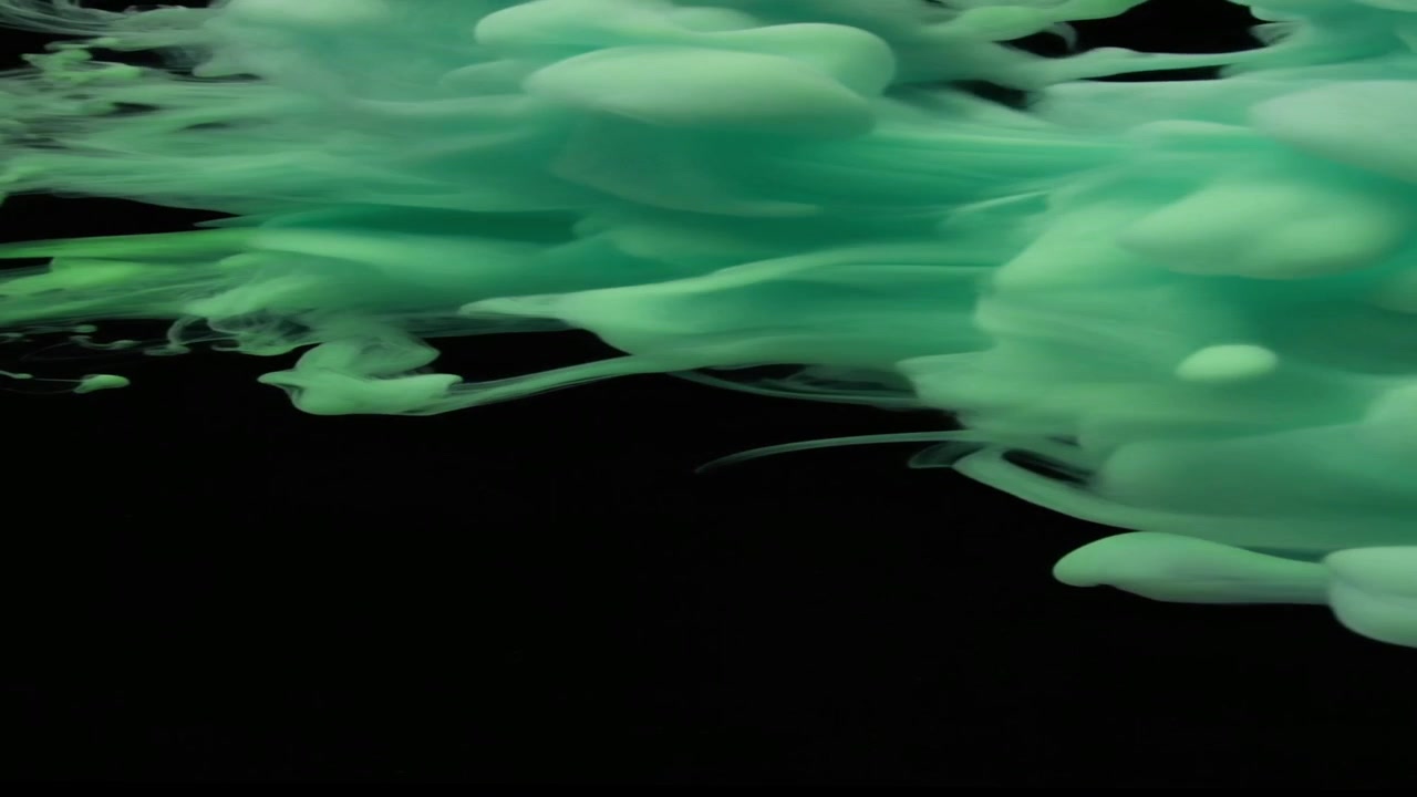 Inchiostro verde che turbina nell'acqua su sfondo nero