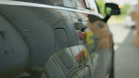 closeup of driver unplugging electric car from charger