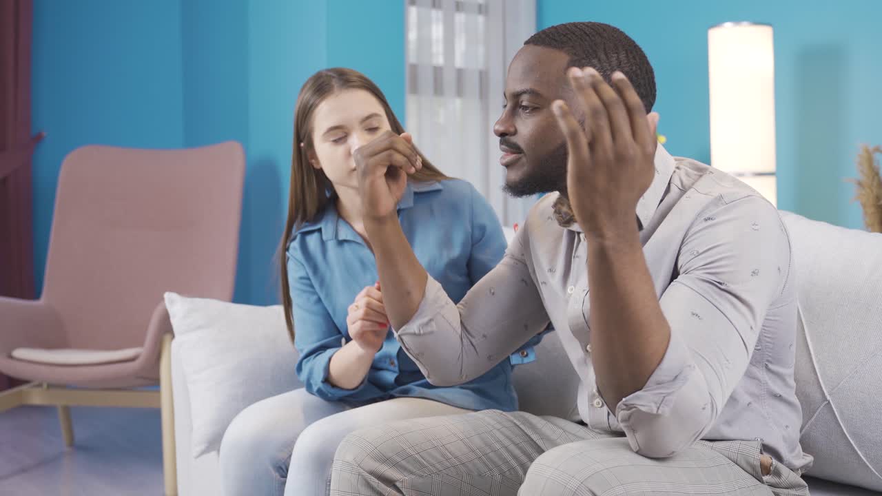 el hombre negro está enojado y su esposa trata de calmarlo.