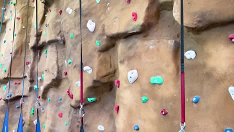 disparo de inclinación que muestra varias posiciones vacías en la pared de escalada en un curso cubierto