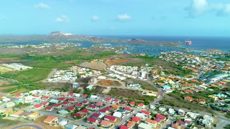 4k-wide-drone-orbit-cinematic-of-houses-and-neighborhoods-near-coast-of-the-Caribbean-island-Curacao,-during-beautiful-stunning-sunny-day