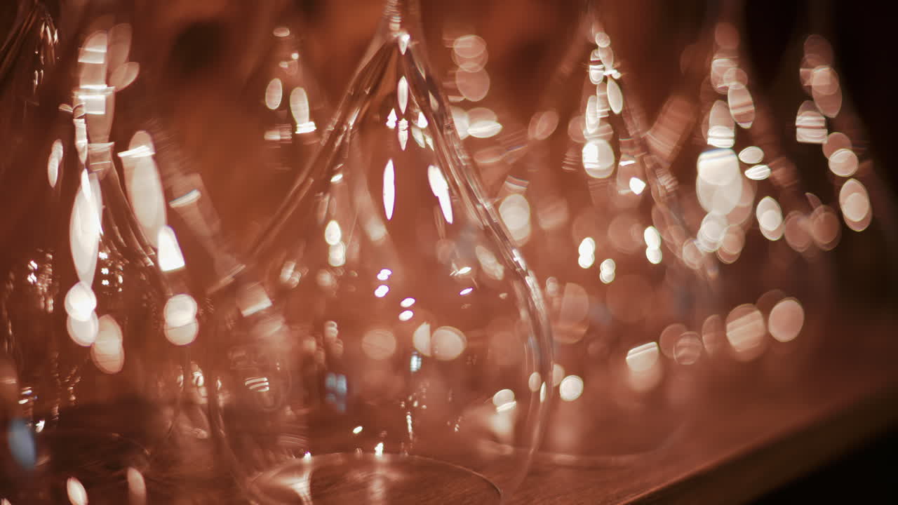 Close up view of multiple glass vessels softly illuminated with warm light that creates a golden bokeh effect in the background