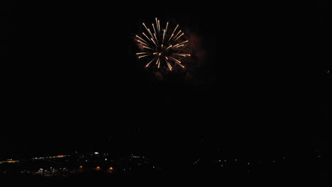 antena de fuegos artificiales sobre un pequeño pueblo con luna