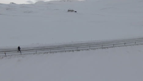woman walking vigorously on winter road in desolate countryside