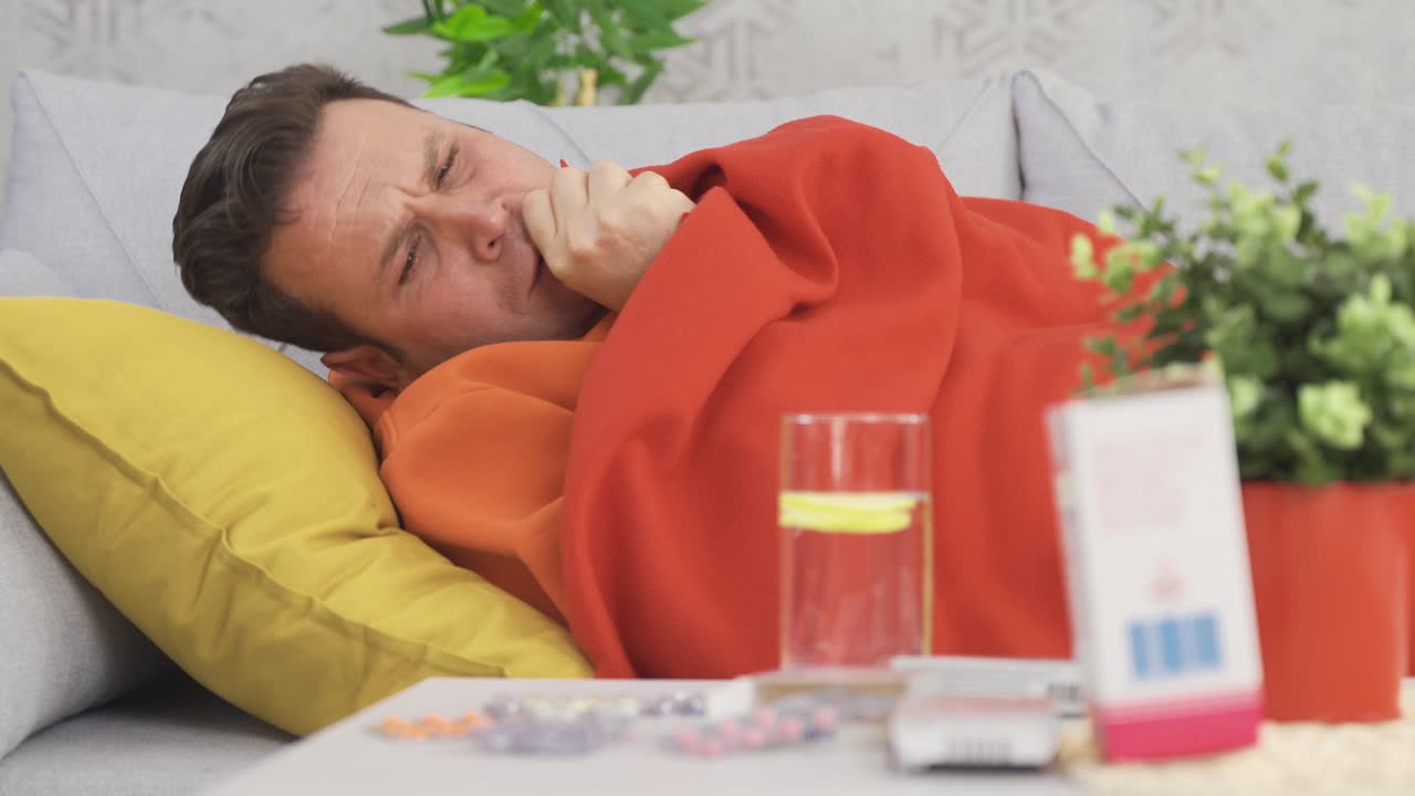 Sick man resting at home and taking medicine.