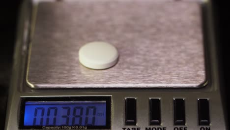 weighing a pill on a digital scale