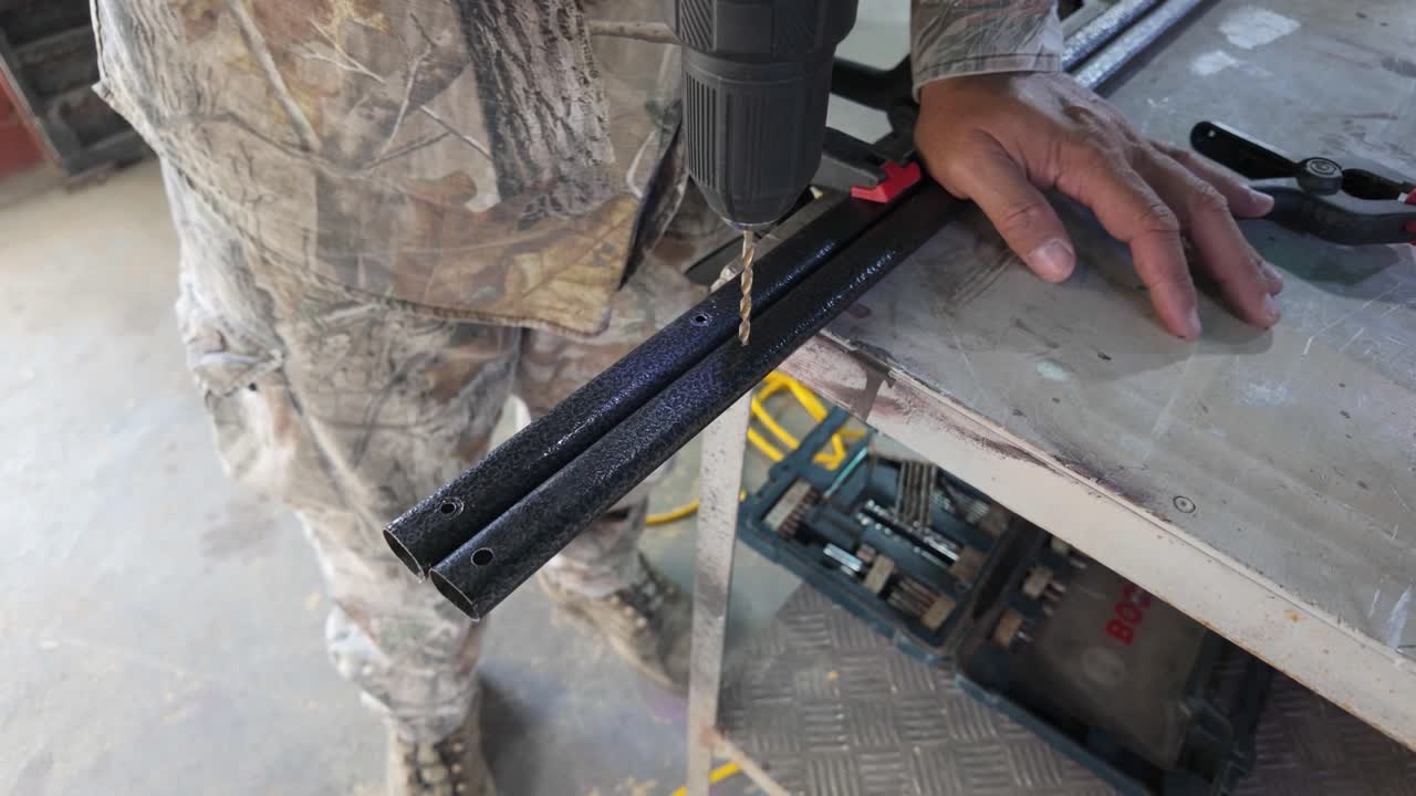 Man drilling metal with precision in a workshop setting