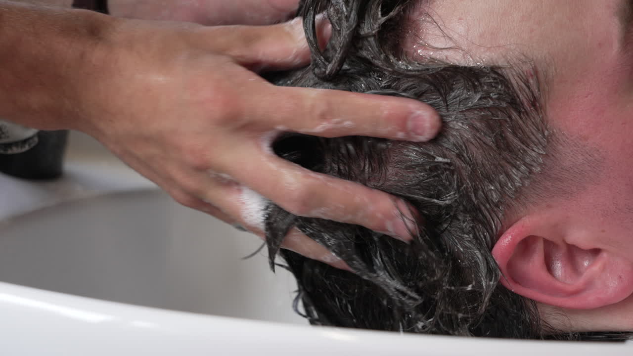 Inquadratura statica al rallentatore di un uomo che si lava i capelli
