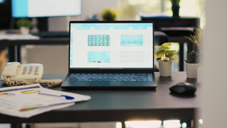 stock market diagrams with charts and stock figures on laptop sitting on desk