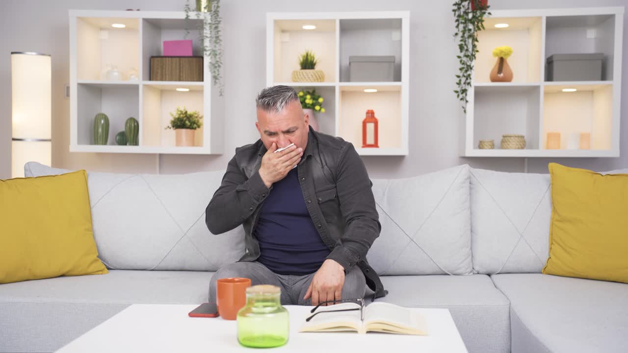 anciano cubriendo la boca y la nariz mientras tose.