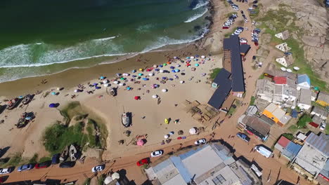 aerial fly over small beach town in punta del diablo, uruguay