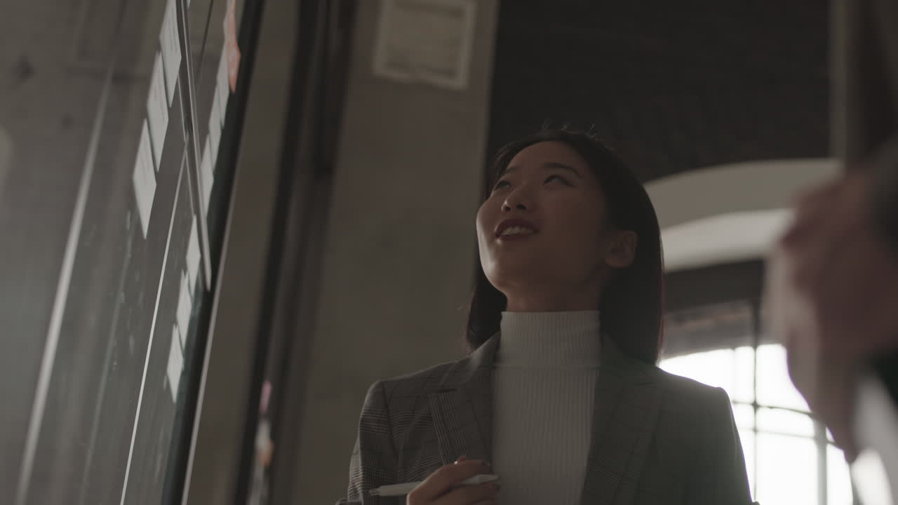 Woman Doing Notes on Glass Board