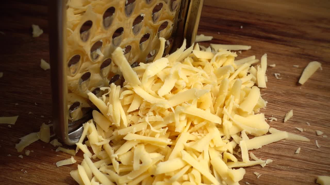Le cuisinier râpe du fromage. Ralenti.
