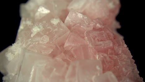 seamlessly rotating a pink mineral (pink halite) in front of black background