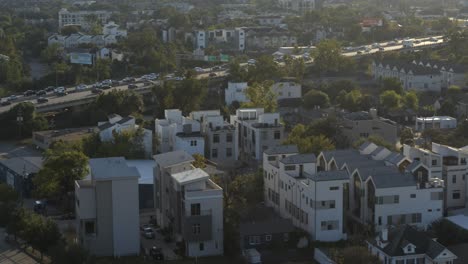 aerial view of modern suburb with highway traffic at sunset