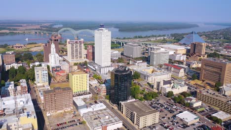 Gute-Stationäre-Luftaufnahme-Des-In-Der-Stadt-Gelegenen-Geschäftsviertels-Von-Memphis-Tennessee-Mit-Hochhäusern-Mississippi-Flussbrücke-Und-Schiff-Entfernt