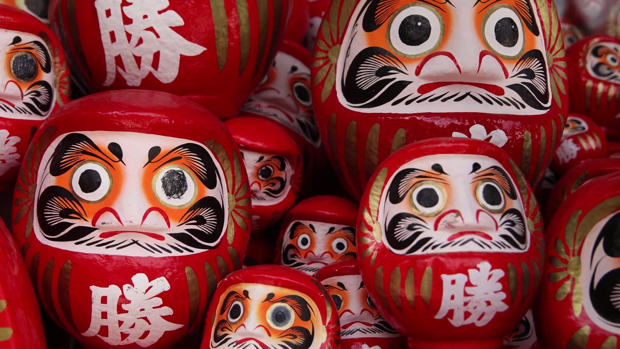 Primo piano di tradizionali bambole Daruma rosse al tempio Katsuo-ji a Minoh, Osaka, Giappone, che rappresentano buona fortuna, determinazione, desideri e vittoria nella cultura buddista giapponese