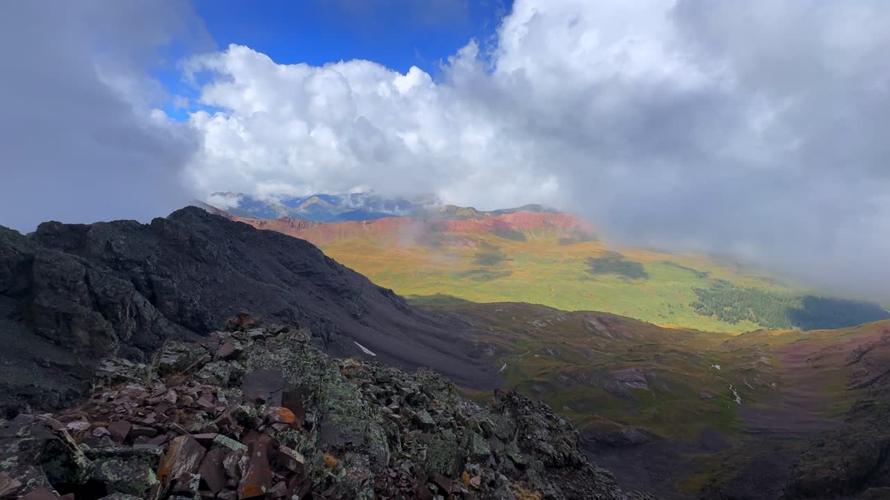 Aspen Snowmass Maroon Bells Wilderness valley Colorado summer panoramic view fourteener Elk Range Rocky Mountains rugged terrain Capitol Peak Mount Snowmass sunny blue sky clouds fog pan right motion