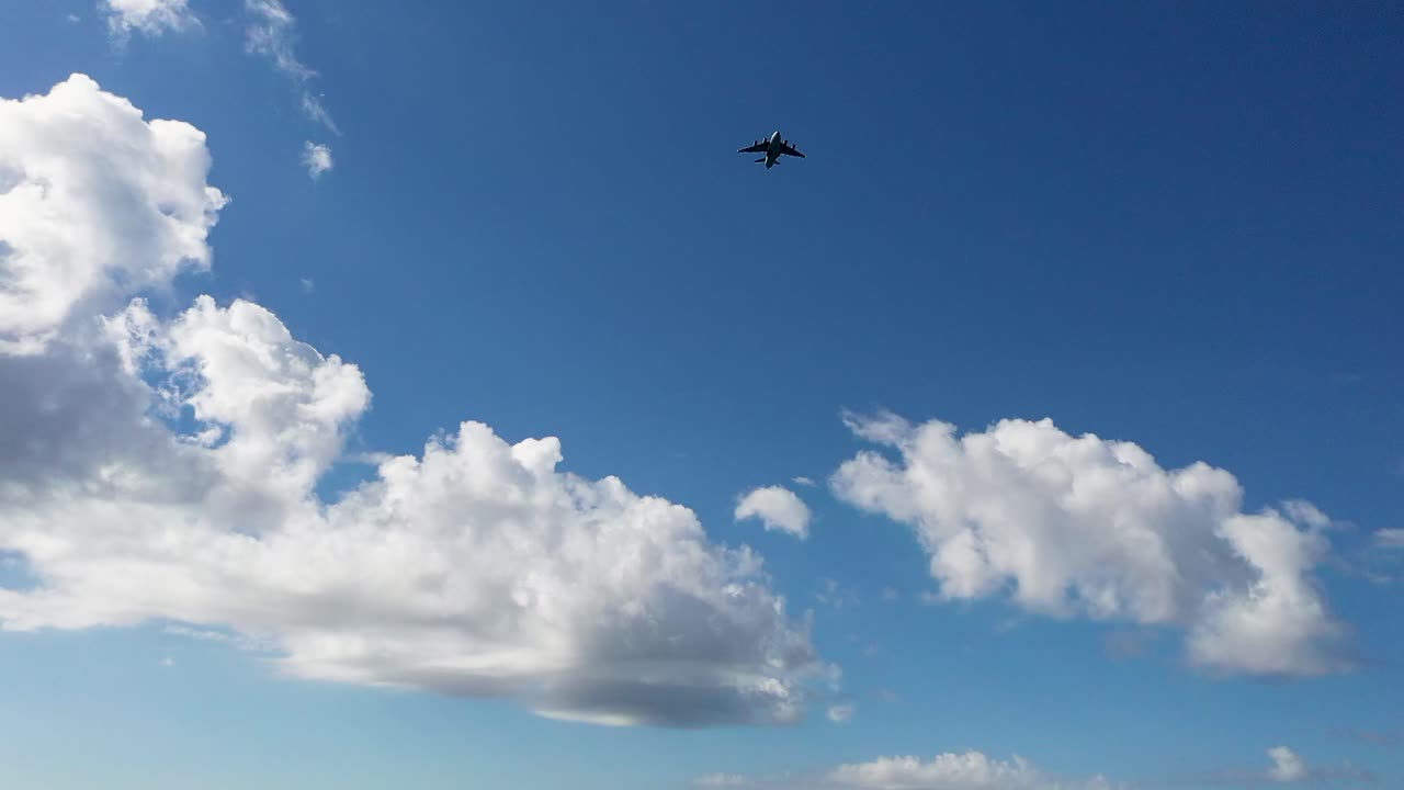 avión de transporte acercándose al aterrizaje del aeropuerto contra las nubes del cielo azul, panorámica