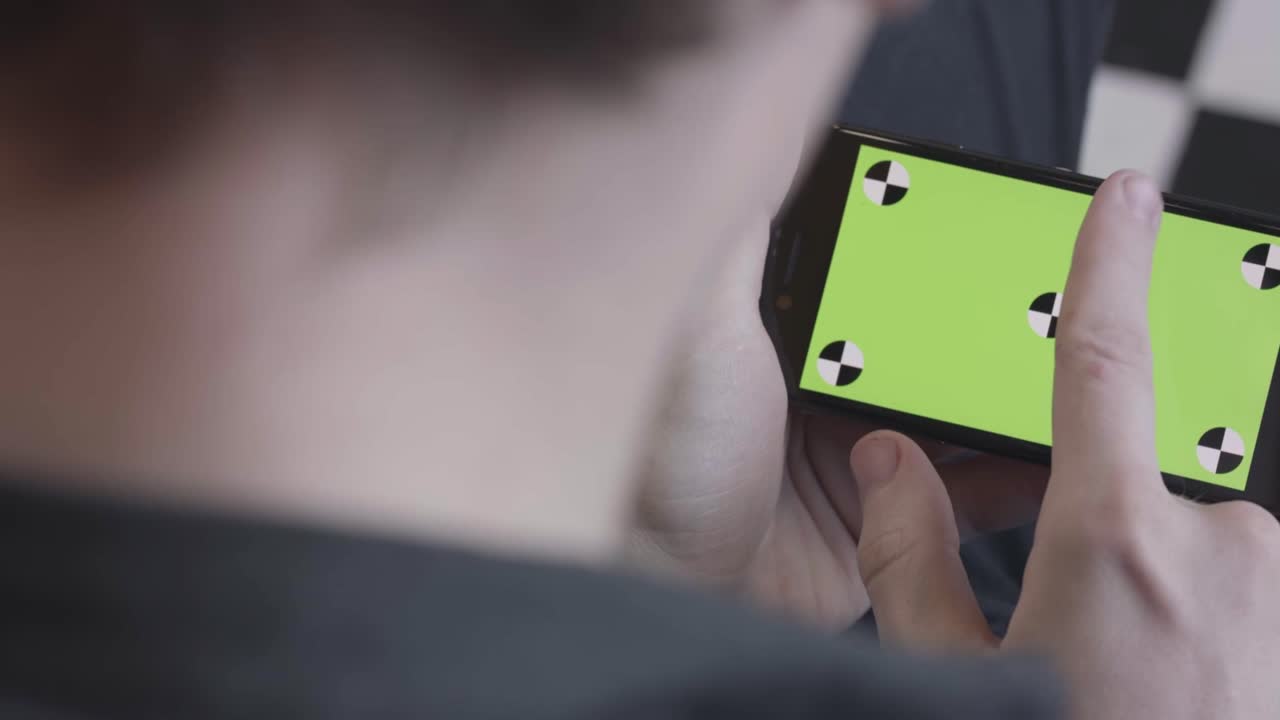 persona che utilizza uno smartphone con schermo verde