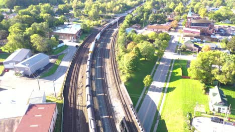 Aus-Der-Luft-über-Einen-Langen-Güterzug-Aus-Öltankwagen,-Der-Sich-Schnell-Durch-Den-Ländlichen-Mittleren-Westen-Bewegt