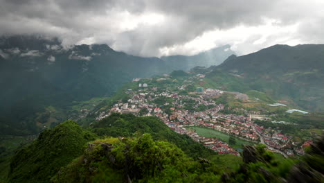 man on mountain viewpoint admiring sapa town and ham rong or dragon’s jaw mount, vietnam. aerial forward