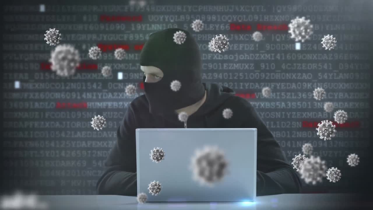 animazione di macro cellule di covid19 su un uomo che indossa una balaclava, usando un portatile