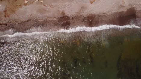 Aerial-Birds-Eye-View-Of-Sea-Waves-Breaking-On-Sandy-Gravel-Beach-In-Costa-del-Sol