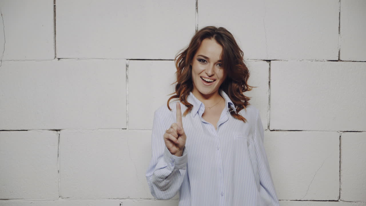 Woman in front of a white brick wall
