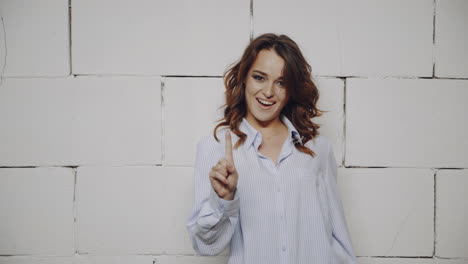 woman in front of a white brick wall