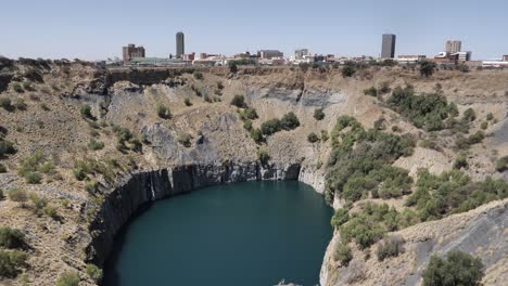 Panorámica-A-Través-De-Un-Enorme-Pozo-Inundado-De-Una-Mina-De-Diamantes-De-Gran-Agujero-En-Sudáfrica