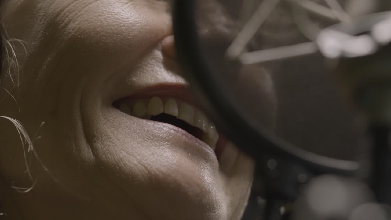 mujer cantando en un micrófono profesional en el estudio, vista de cerca
