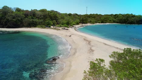 Vuelo-De-Drones-A-Través-De-La-Popular-Playa-De-Arena-De-San-Juanillo-Con-Océano-Azul-A-Ambos-Lados-De-La-Costa,-Costa-Rica-4k