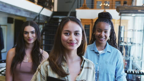 Retrato-De-Un-Sonriente-Equipo-De-Ventas-Femenino-Multicultural-En-Una-Tienda-De-Moda-Frente-A-Una-Exhibición-De-Ropa