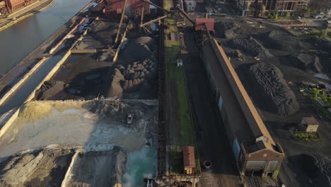 industrial building site complex with piles of raw material, aerial view