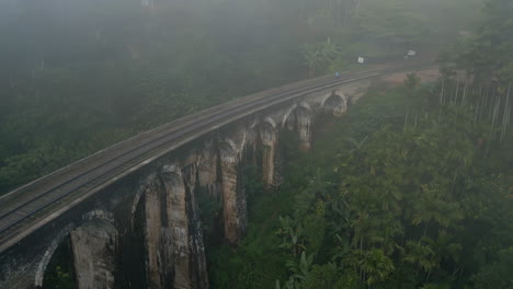 pullback establishing drone shot of 9 arches bridge on foggy morning in ella sri lanka