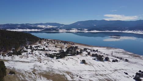 Ascending-drone-shot-reveal-lake-with-reflection-of-a-mountain-and-clouds