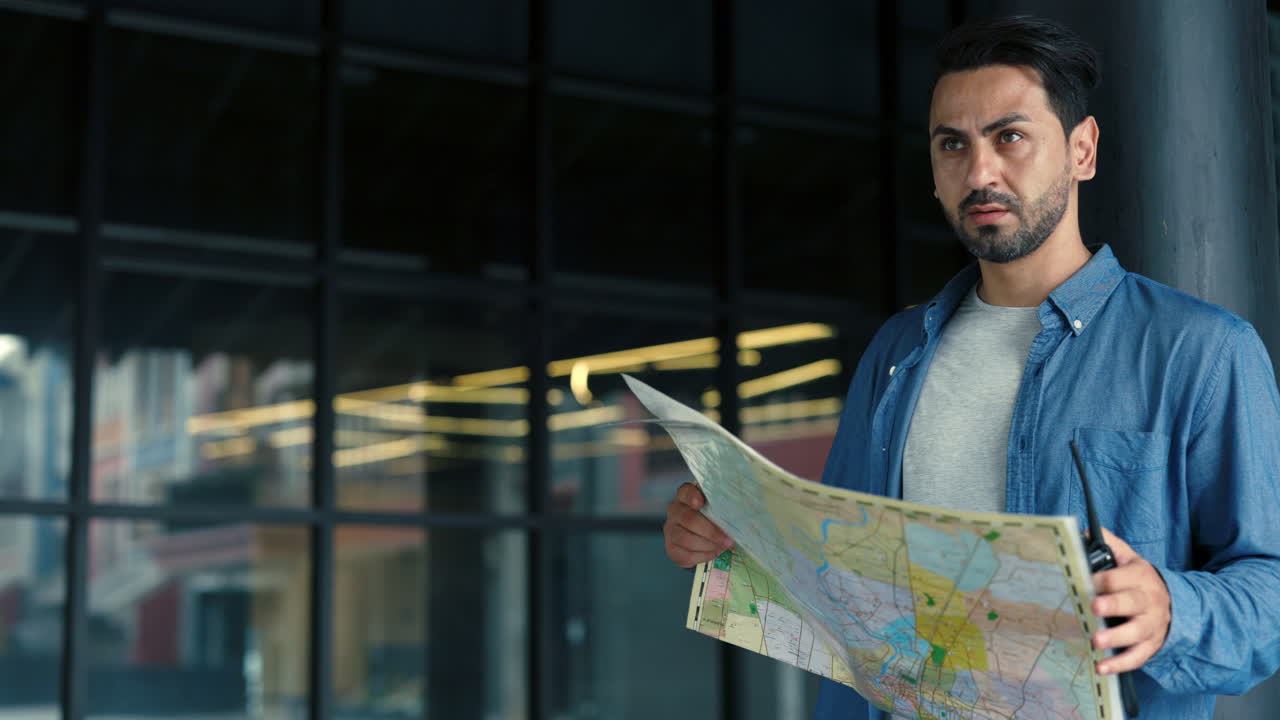 Man Looking at Map and Using Walkie-Talkie in City