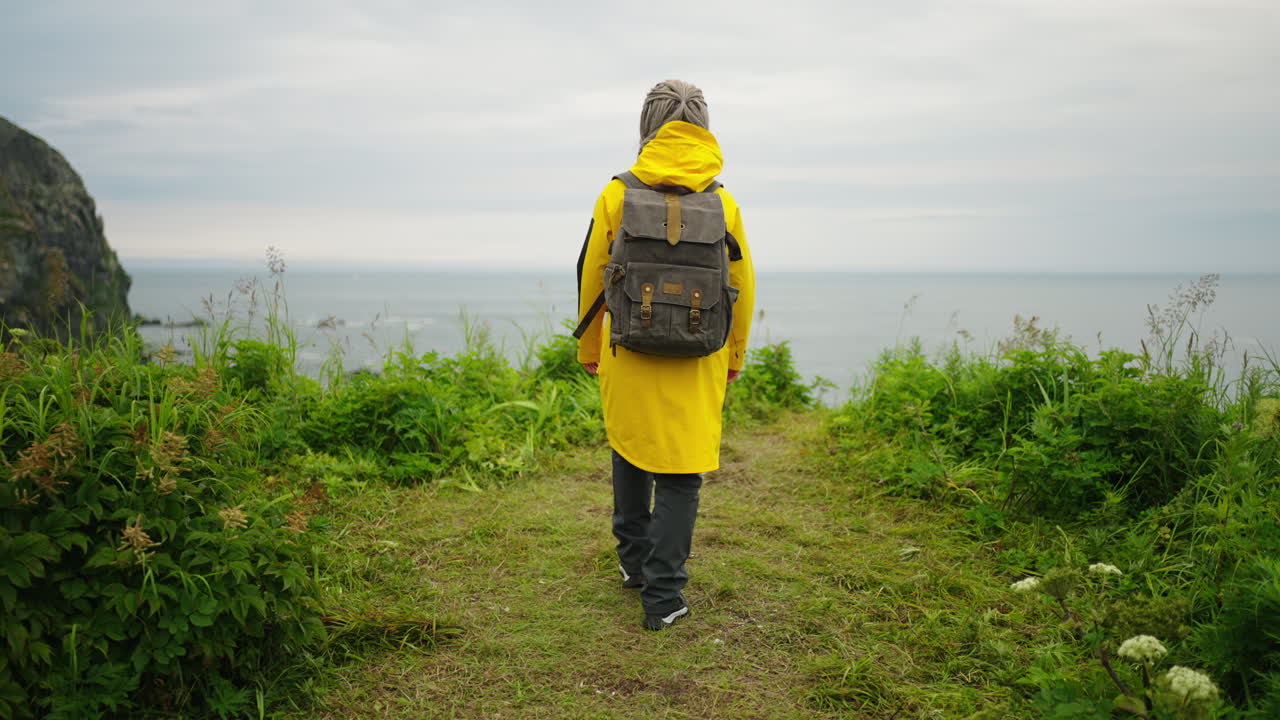 Person Hiking Along a Coastline